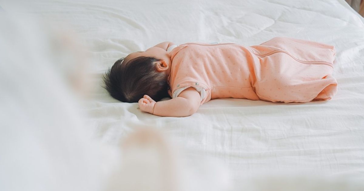 赤ちゃんがergoPouchのスワドルを着てぐっすり眠っている