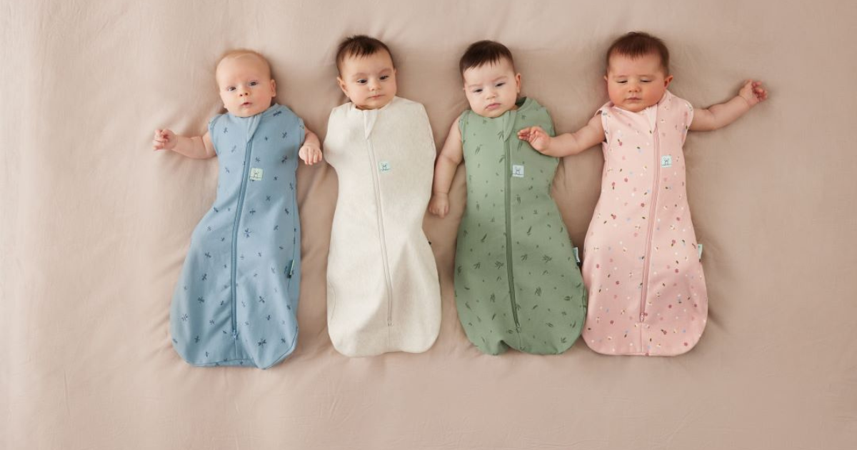 ergoPouchのスワドルを着ている4人の赤ちゃんが横になって並んでいる