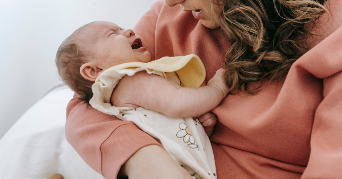 【新生児の夜泣き対策におすすめ】赤ちゃんが安心して眠れるエルゴポーチのスワドルの説明をしている